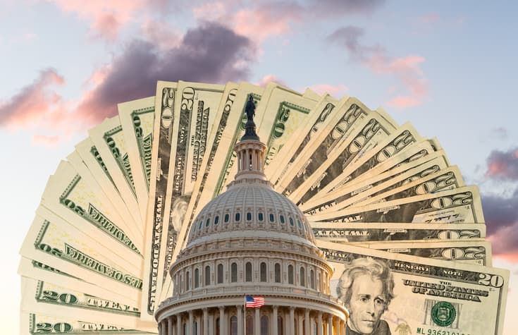 US flag flies in front of the US Capitol in Washington DC with cash behind the dome to illustrate coronavirus stimulus payment