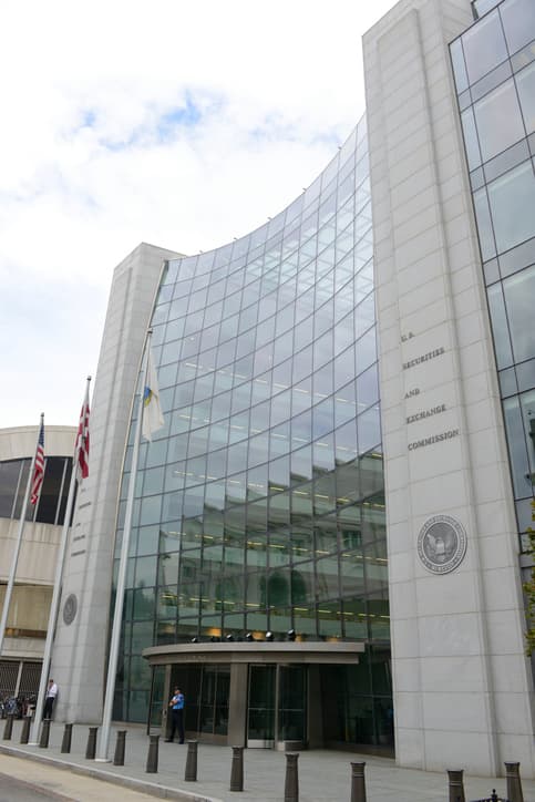 "Washington, DC, USA - October 4, 2012: The United States Securities and Exchange headquarters building located on F Street in Washington, DC. A security guard and other people are present in this photo. The U.S. Securities and Exchange Commission hold primary responsibility for enforcing federal securities laws."