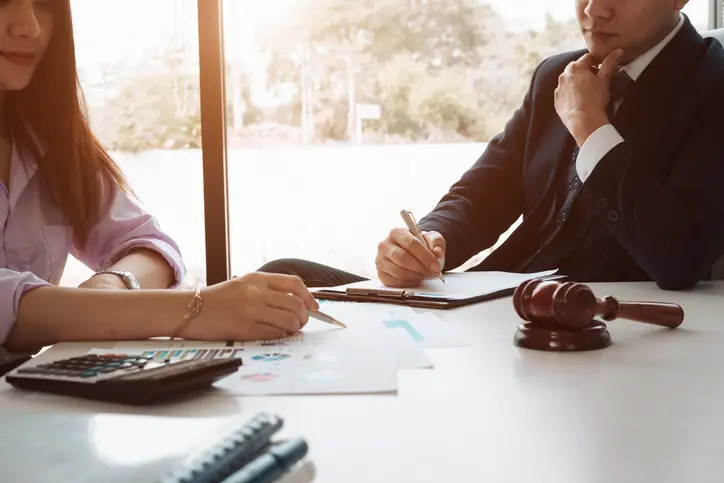 Image of a business man supervising and secretary executing business plan. Consultant analyzing company annual financial report balance sheet statement working with documents graphs; visualizes an audit and consultant.