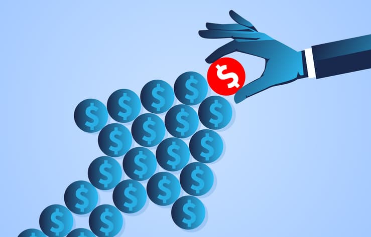 An arrow made up of blue dollar coins. The tip of the arrow has a red dollar coin, which is being placed by a businessperson.