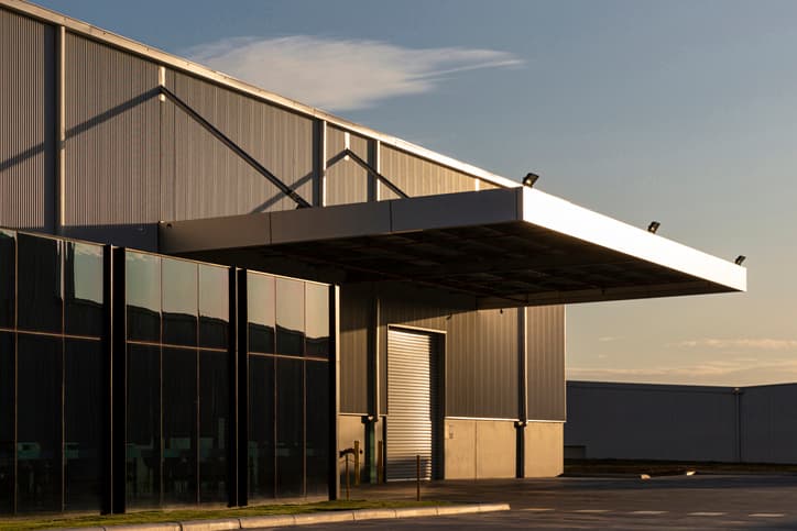 Industrial office &amp; warehouse architecture bathed in afternoon light.