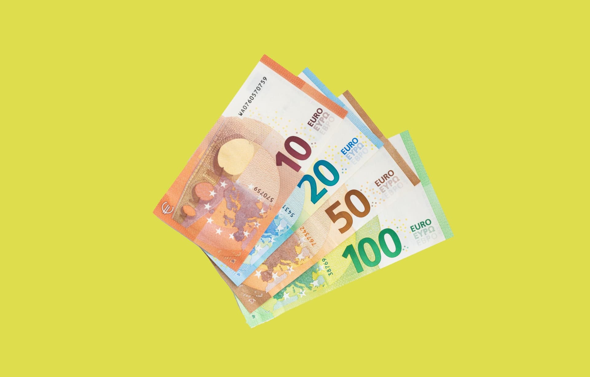 Euro notes fanned out on a green background