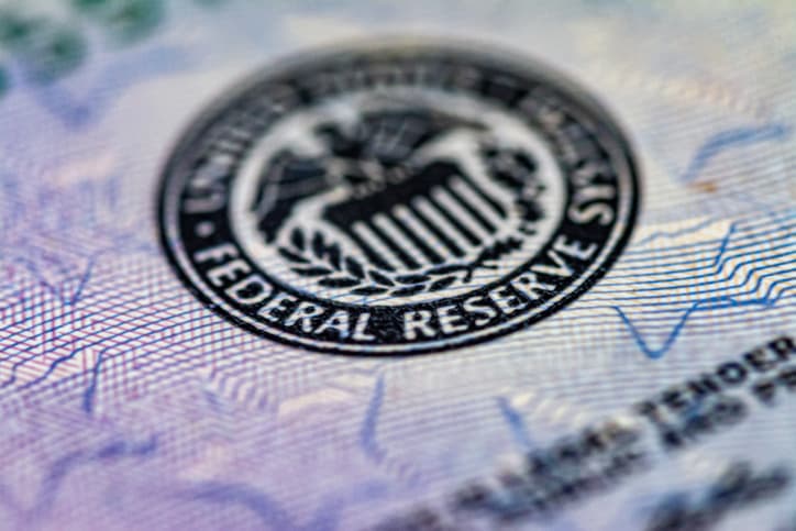 Zoomed image of US dollar featuring Federal Reserve symbol.