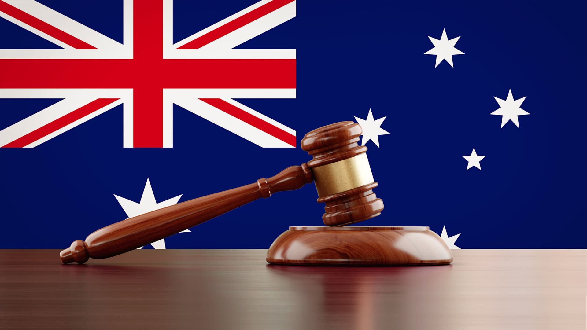 Wooden gavel in front of Australian flag. The gavel is nicely textured and it is casting soft shadows on the ground. Great use for law, justice and auction related concepts.