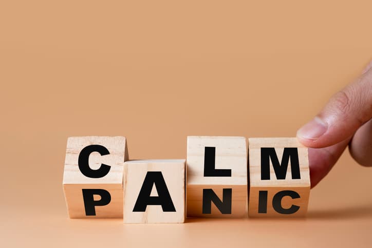 Hand flipping wooden cubes for change wording" Panic " to " Calm". Mindset is important for human development.