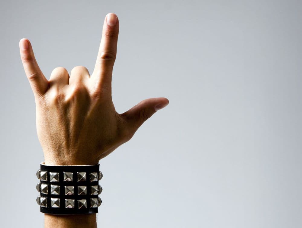 Photo of headbanger making hand sign, also known as devil horns.