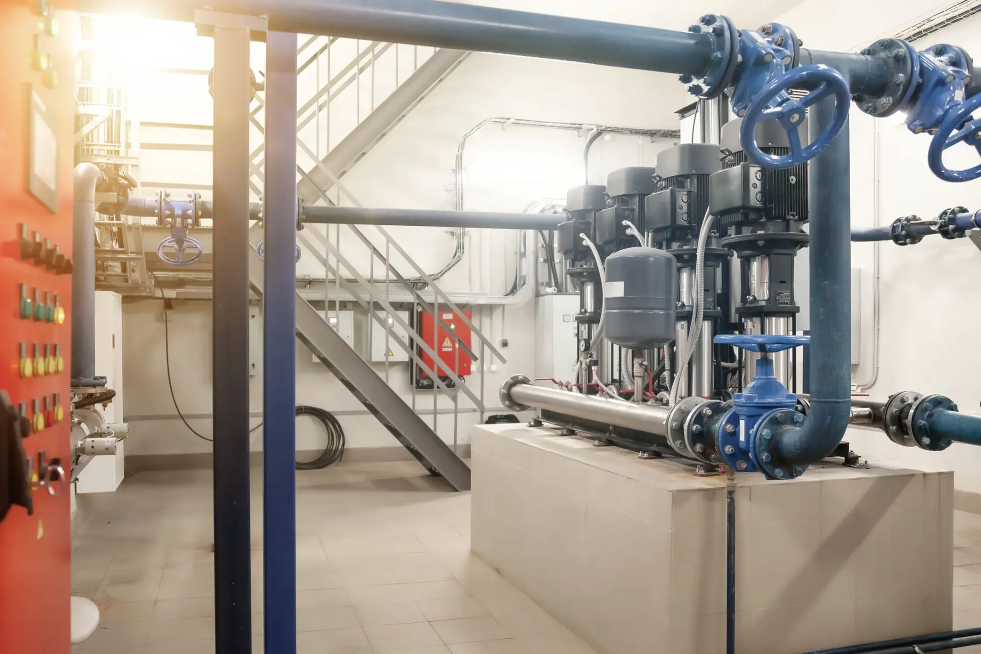Industrial pumps in an engine room. Industry interior of water pump, valves, pressure gauges, motors inside technical room. Automatic control systems. Urban modern powerful pipelines