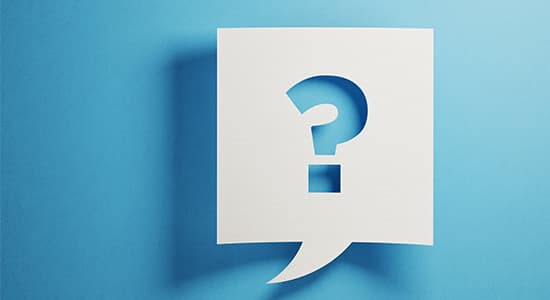 question mark cut out of card on a blue blackground